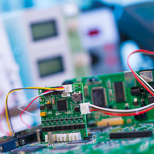 PCB being tested, oscilloscope in background